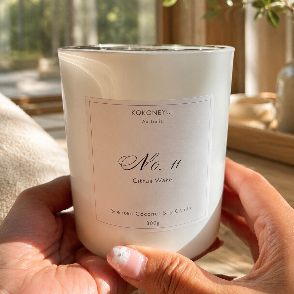 Hand holding a white candle labeled &