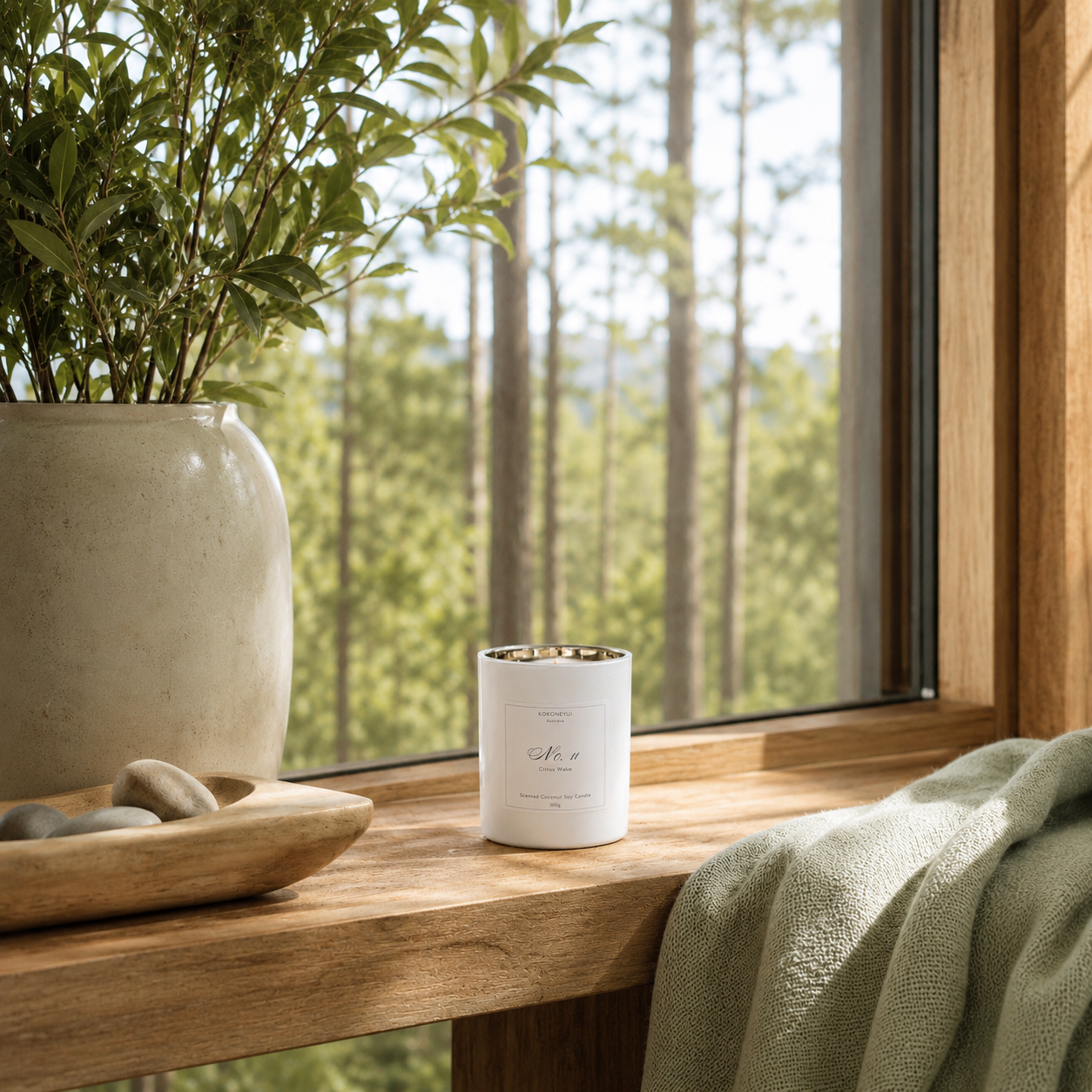 Candle on a windowsill with a view of trees