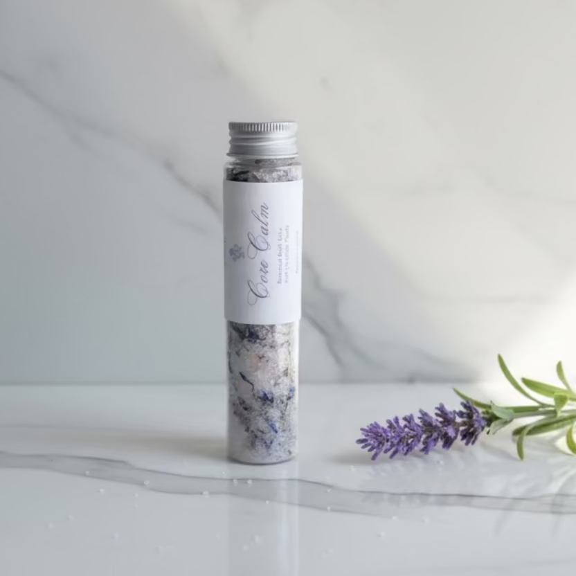 Tub of bath salts with a label on a neutral background