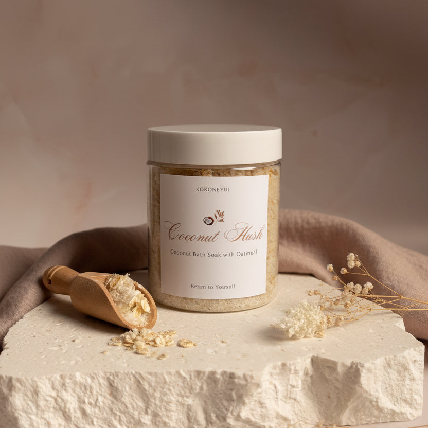 Jar of coconut Hush with a scoop on a white surface