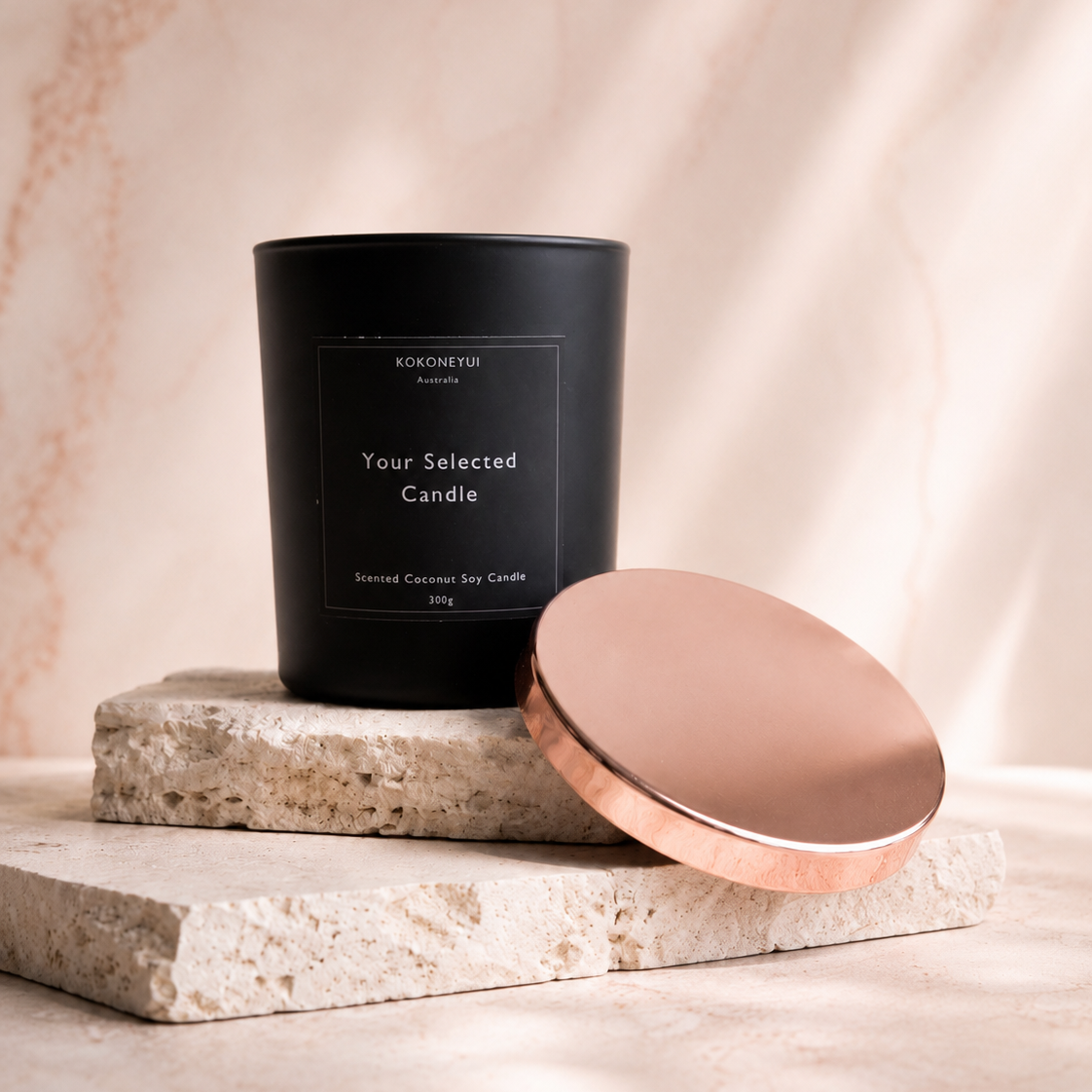 Matte Black candle with a Rose Gold lid on a stone surface against a beige background
