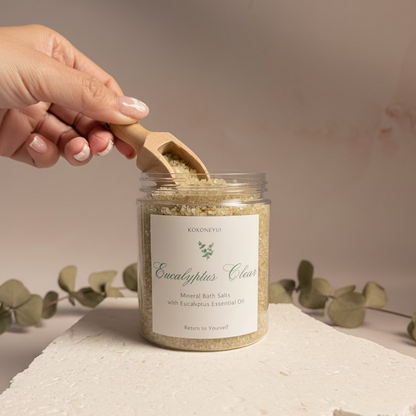 Jar of Eucalyptus Clear product with a wooden scoop on a light gray background