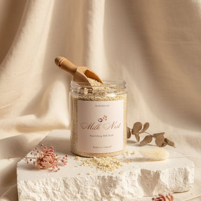 Jar of 'Milk Nest' bath Milk with a wooden scoop on a light surface.
