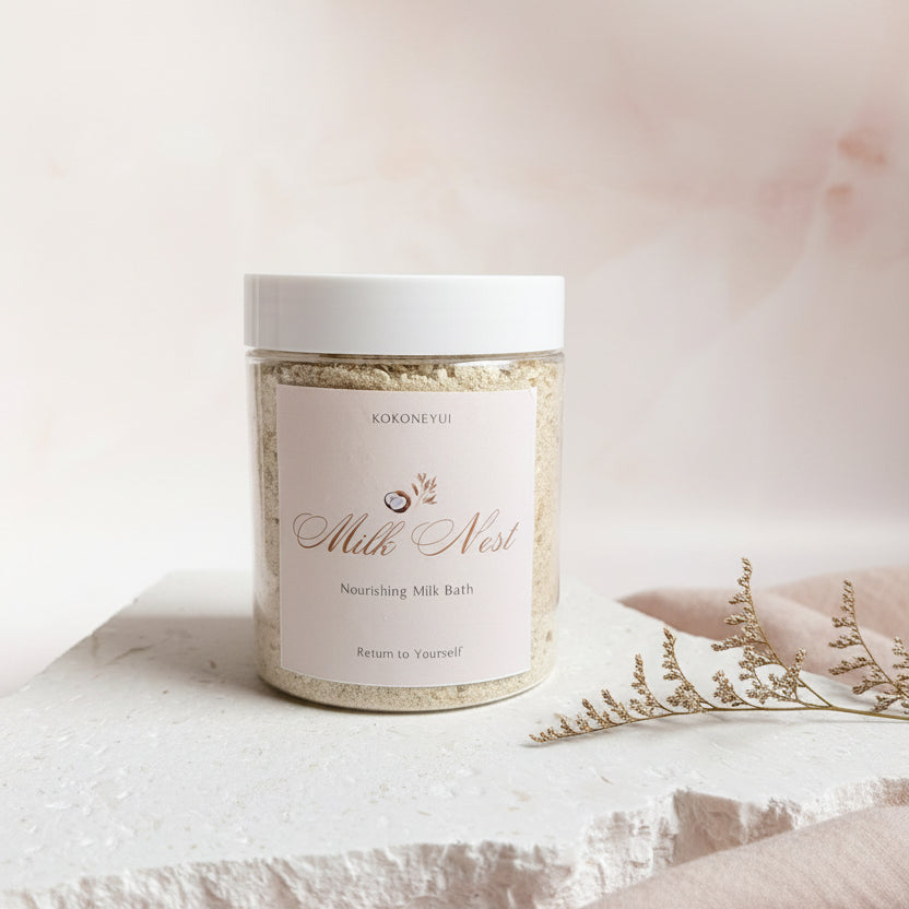 Jar of Milk Nest Bath Milk on a textured white surface with a light gray background
