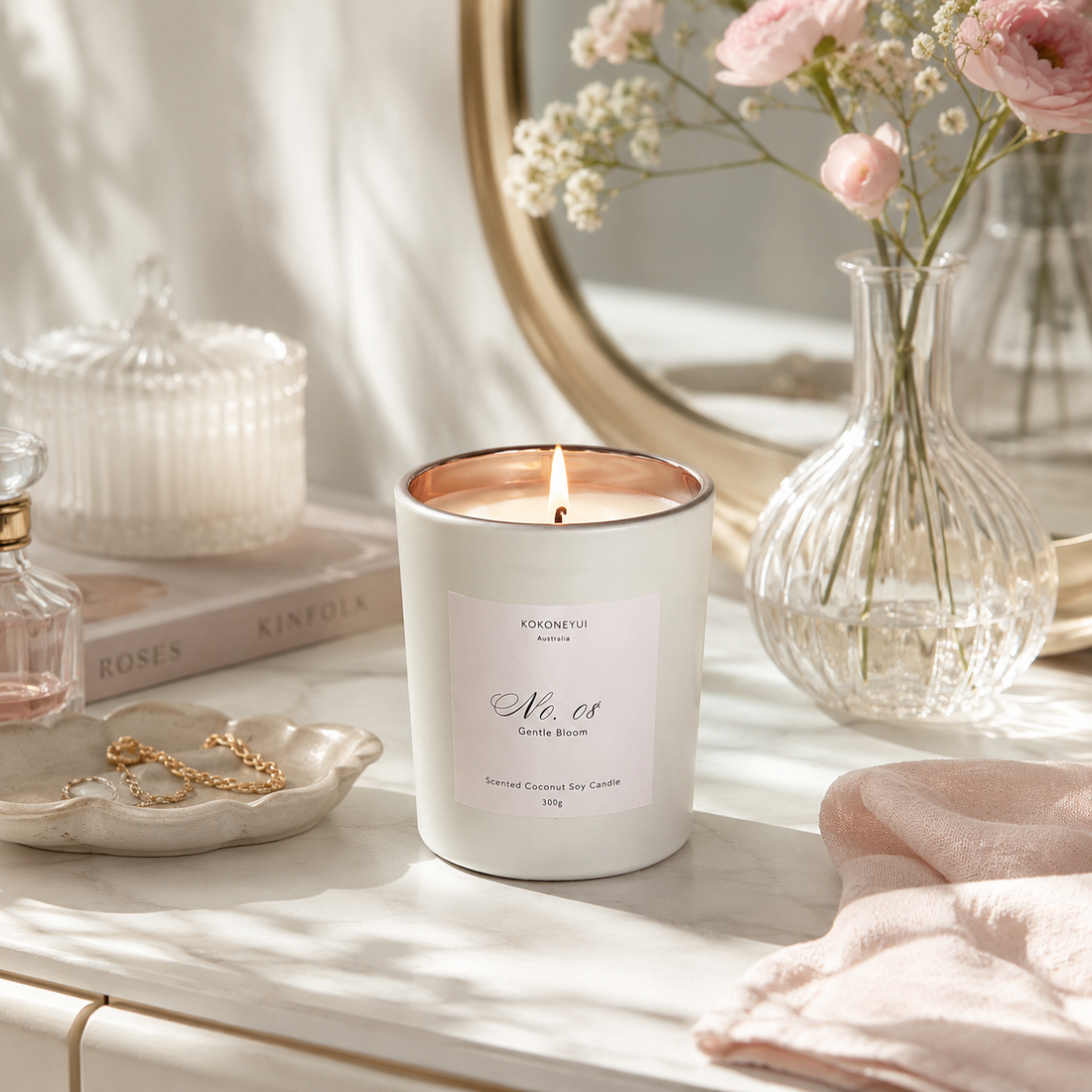 Candle on a table with flowers and decorative items in the background