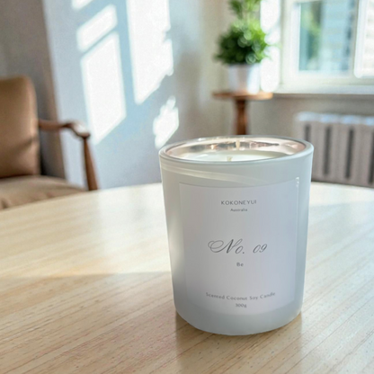 Candle with a label on a wooden table in a bright room
