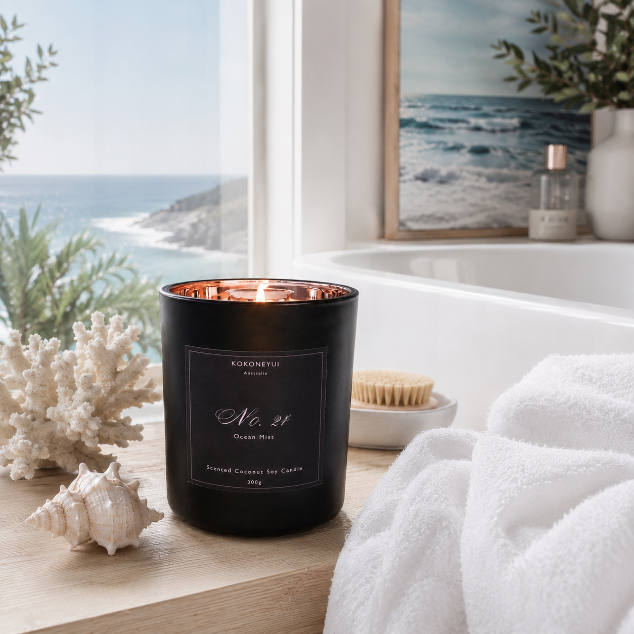 Black candle with a label in a bathroom setting with a bathtub and ocean view.