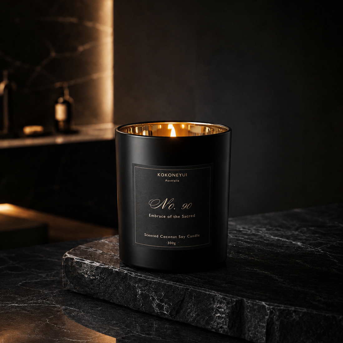 Black candle with gold interior on a dark surface, brand &