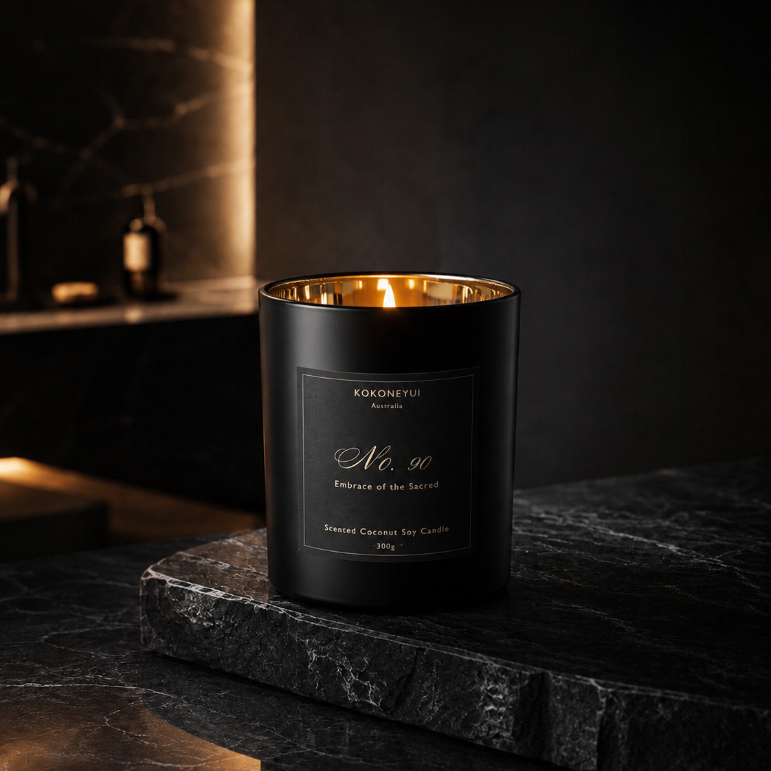 Black candle with gold interior on a dark surface, brand &