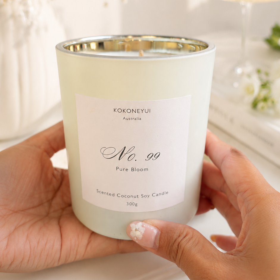 Hand holding a white candle labeled &