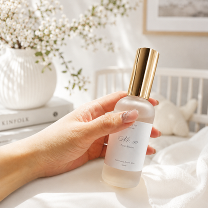 Hand holding a room mist bottle labeled &